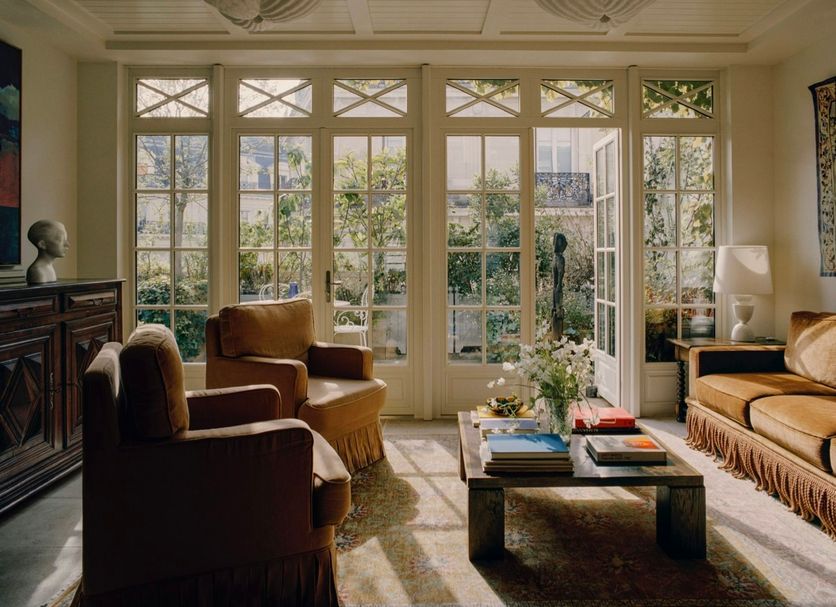 Château Voltaire in Paris living room with tall windows, armchairs and coffee table