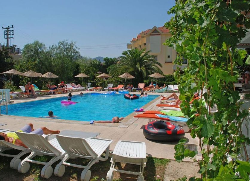 Nur Apart in Marmaris: outdoor pool with sun loungers, umbrellas, and guests relaxing in the water