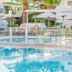 Club del Carmen in Tías with a turquoise outdoor pool, glass railing, and sun loungers