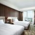 LOTTE CITY HOTEL DAEJEON room with twin beds, city view, desk and wall-mounted TV