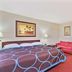 Super 8 by Wyndham Jacksonville Orange Park room with king bed, red sofa and work desk in Jacksonville