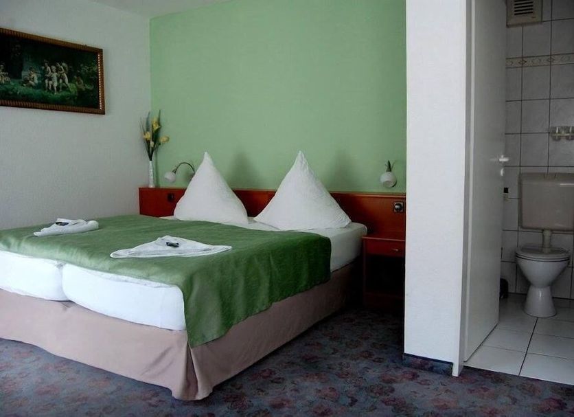 Hotel Am Markt in Eckartsberga: twin bed room with attached bathroom and green walls