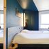 Ibis Budget Rochefort guest room with two beds, blue walls, and a window in Rochefort