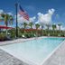 Home2 Suites by Hilton Fort Walton Beach Eglin Air Force Base pool with palm trees and lounge chairs