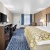 Baymont by Wyndham Port Arthur/Groves Area guest room with bed, TV, desk, and window seating
