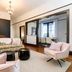 Naramata Inn guest lounge with floral accent wall, pink chairs, dark wood floors and dining nook