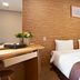 Hotel Skypark Myeongdong Ii room in Seoul with three twin beds and wood-paneled accent wall