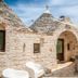 Almapetra Trulli Resort in Locorotondo, stone trullo courtyard with outdoor dining area
