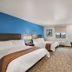 My Place Hotel-Colorado Springs,co guest room with two beds, desk, TV, and blue accent wall