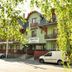 Hotel Hajnal in Mezőkövesd, tree-framed exterior with balconies and parked vehicles