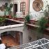 Hotel del Vasco in Zacatecas courtyard with hanging white chairs, potted plants, and arched walkway