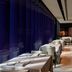 W Doha Doha restaurant with white tablecloth dining tables beside floor-to-ceiling purple-tinted windows