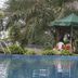 Kiriri Residence Hotel in Bujumbura: outdoor pool with green umbrella and palm trees