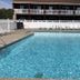 Nader's Motel & Suites in Ludington outdoor pool with lounge chairs and motel balcony