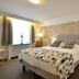 Hotel Schilberg in Slenaken guest room with double bed, bedside lamps, window and mirrored wardrobe