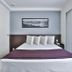 San Diego Suites Pampulha Hotel in Belo Horizonte: bed with purple runner, pillows and window curtains