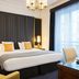 Melia Paris Champs Elysees guest room in Paris with a king bed, chandelier, and balcony doors