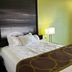 Super 8 by Wyndham Nebraska City guest room with king bed, bedside lamp, and lime green walls in Percival
