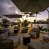 Hilton Garden Inn San Juan Condado rooftop terrace with lounge seating and city skyline at sunset