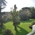 Las Carolinas Garden Santander hotel with lush garden, lawn, palm trees and sunny outdoor view