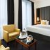 Melia Paris Champs Elysees room in Paris with king bed, yellow armchair, and bedside lamps