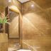 Hotel Waves, Delhi Airport bathroom with white vessel sink and brown marble-tiled walls in New Delhi