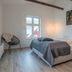 Við Lónið Guesthouse room in Seydisfjordur with bed, window view, wood beams and hanging lights