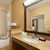 Hampton Inn Battle Creek bathroom with tub, shower grab bars, and vanity sink