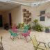 Rosa Mexicano Hostal in Mérida, courtyard patio with colorful chairs, table, and potted plants