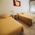 Tagüe in Gualeguaychú: twin bed hotel room with tiled floor, bedside lamp and curtained window