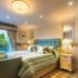 Crossbasket Castle Glasgow bedroom with king bed, armchair, and patio doors to garden