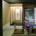 Matsubaya Ryokan Kyoto tatami room with low table, cushions, shoji screen, and garden view
