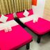 Woodstock Hostel Hong Kong room with two bright pink beds and folded towels