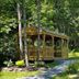 Bucksport Inn in Bucksport features a wooden gazebo surrounded by lush forest and landscaped greenery.