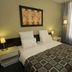 C Hotel Tiberias guest room with double bed, bedside lamps, wall art, and sheer curtains