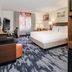 Fairfield Inn & Suites by Marriott Houston Westchase guest room with king bed, TV, desk and mini fridge
