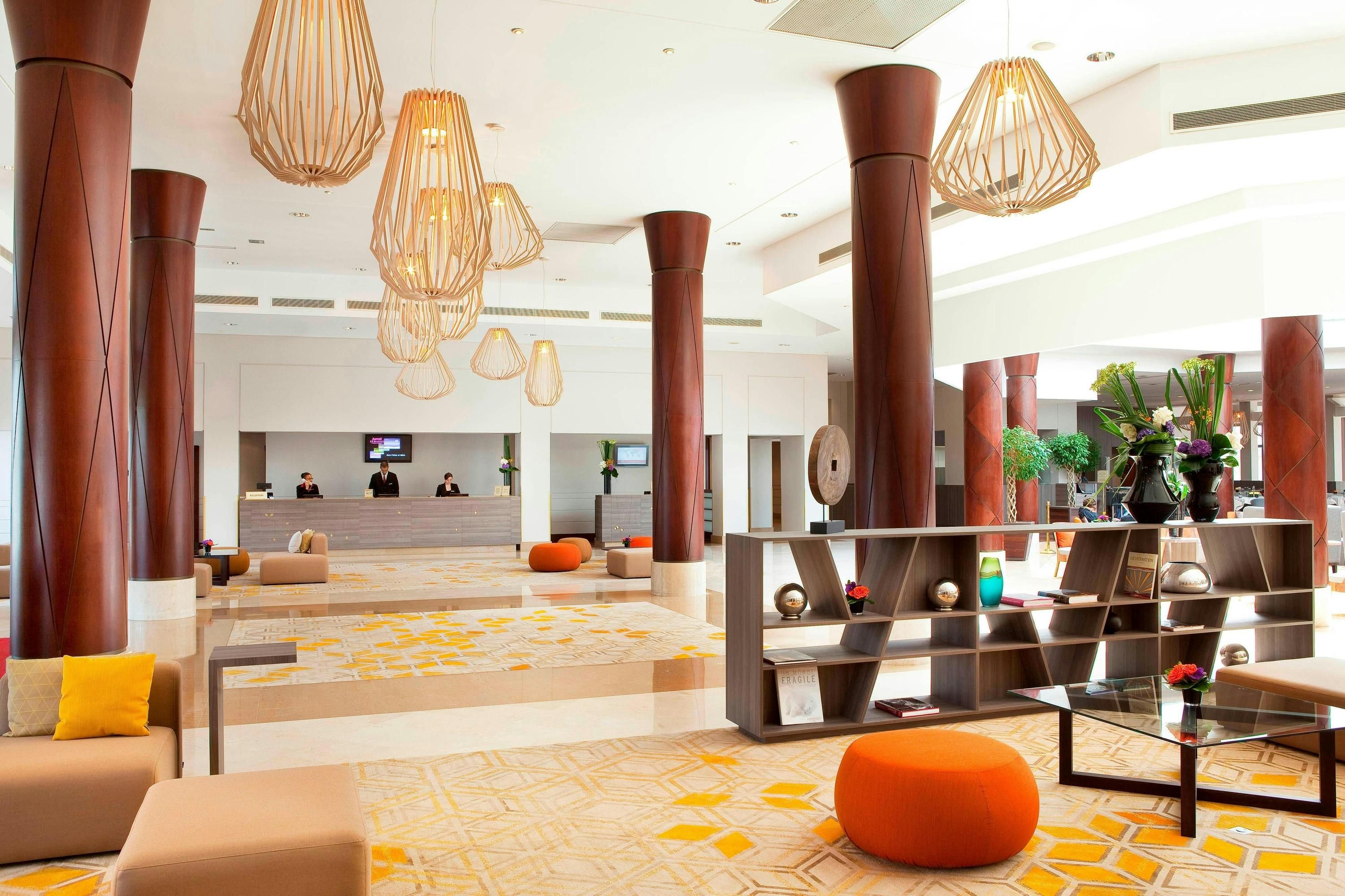 Paris Marriott Charles De Gaulle Airport Hotel lobby in Roissy-en-France with tall wooden columns and lounge seating