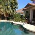 Happy Valley House Phoenix pool surrounded by palm trees and a patio with a resort-style setting