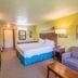 Parkwood Lodge in Fish Creek guest room with king bed, sofa, TV and bright yellow accent wall