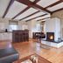 Nürburgring Ferienpark in Nuerburg living room with fireplace, wood beams, bar stools and wall-mounted TV