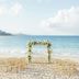 Cheval Blanc St-Barth beach wedding setup with floral arch and gold chairs on the sand in Gustavia