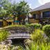 Boma Inn Nairobi in Nairobi with lush garden, small bridge, and palm trees outside the hotel