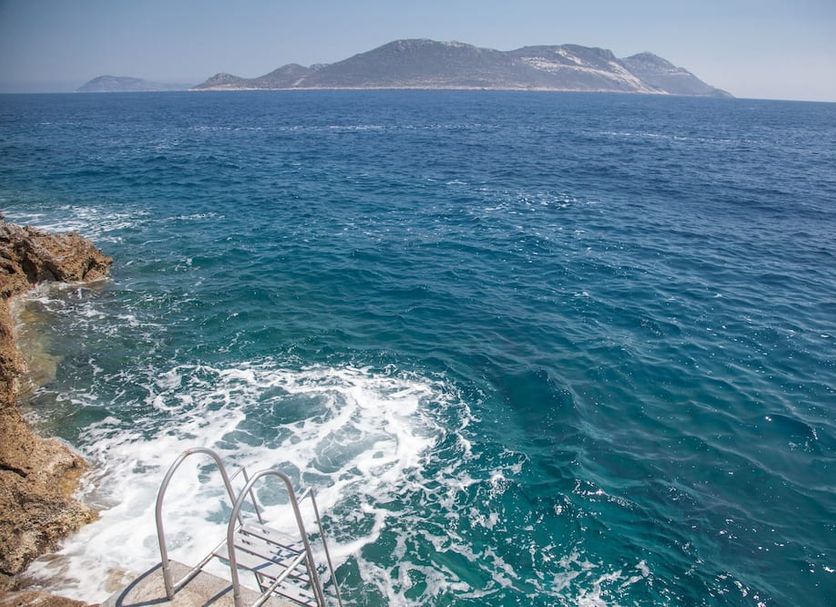Sunset Villa Hotel in Kaş with rocky seaside access and views of the open sea and distant island
