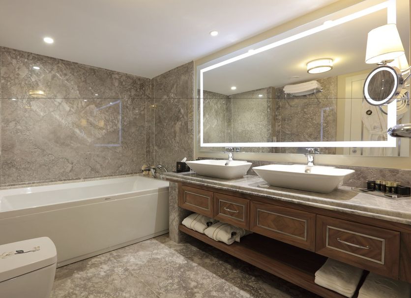 Latanya Hotel Ankara bathroom with marble tub, double sink vanity and large illuminated mirror