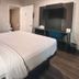 Motel 6 Sacramento West guest room with king bed, desk, TV, and open bathroom door in Sacramento