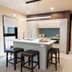 Ashmore Palms Holiday Village kitchen with island, bar stools, and stainless steel fridge in Ashmore