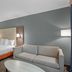 Best Western Porterville Inn guest room with king bed, sofa and wall-mounted lamps in Porterville