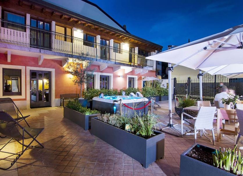Hotel Fontana Verona courtyard with hot tub, patio seating and umbrellas in Verona