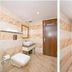 Hotel Golden Inn Chandigarh bathroom with tiled walls, toilet, sink and walk-in shower