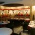 Hotel Art in Sarajevo dining room with set tables, red cushions, and warm wall lighting